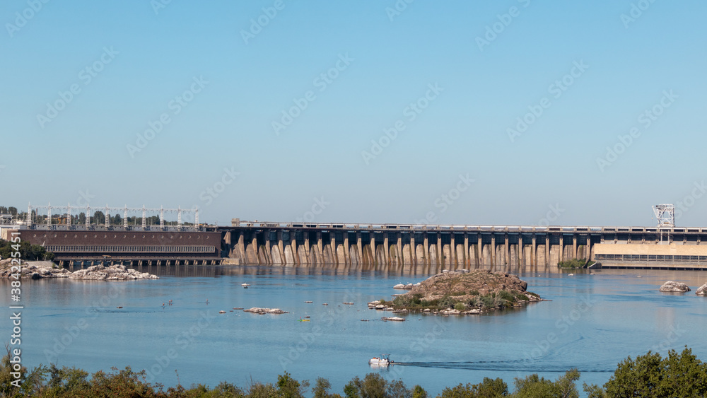 Dneproges on sunny clear day. Hydro electric power plant on Dnieper river in Zaporozhye, Ukraine. View from Khortytsia island