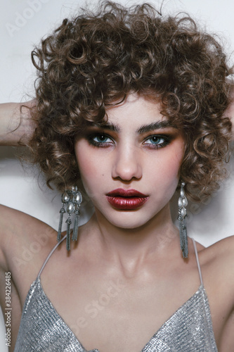 Young beautiful woman with curly hair and smoky eye makeup