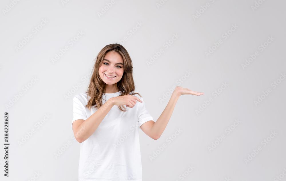 Beautiful young woman pointing to the side presenting product, isolated over a white background Beautiful young woman pointing to the side presenting product, isolated over a white background