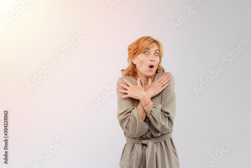 Portrait of wondered charming adult woman with mouth opened over white background