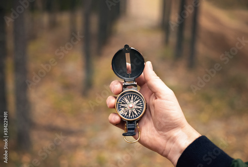 Compass in man's hand on forest background