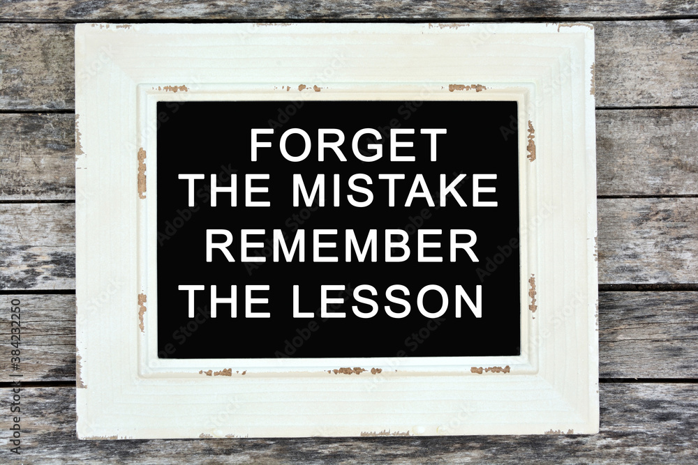 Fototapeta premium Text Forget the mistake remember the lesson written on chalkboard