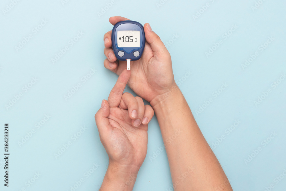 Man using glucometer, checking blood sugar level Man using glucometer, checking blood sugar level