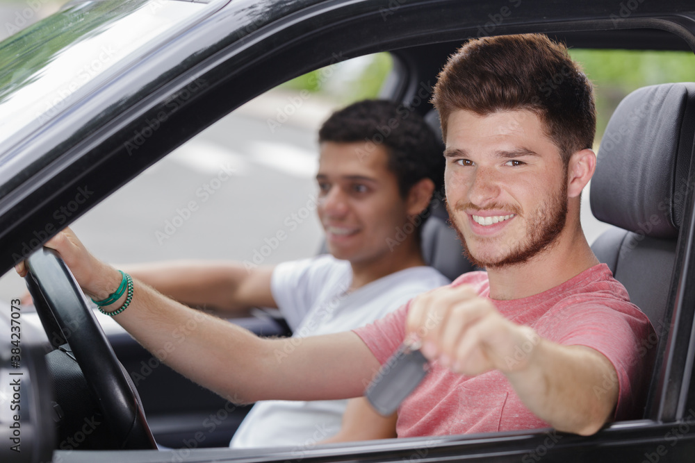 handsome young man with the key inside of his car handsome young man with the key inside of his car