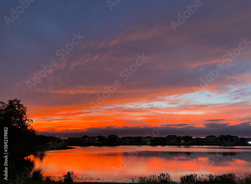 Beautiful pink, orange and blue sunset reflecting on a lake © Joni