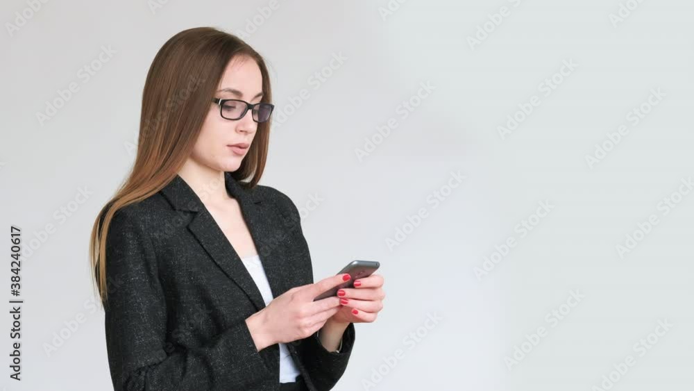 Business chat. Distance communication. Portrait of confident woman in suit working on project online using phone isolated on neutral copy space background. Mobile technology. New normal. Business chat. Distance communication. Portrait of confident woman in suit working on project online using phone isolated on neutral copy space background. Mobile technology. New normal.