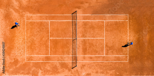 Obraz na płótnie View from above, aerial view of two people playing tennis on a clay court during the Coronavirus (Covid-19) outbreak. w salonie