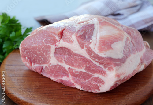 Raw pork neck boneless collar over wooden board