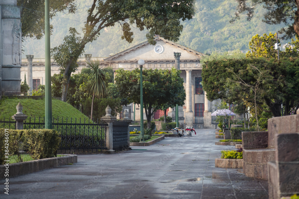 Central park of Quetzaltenango Guatemala early in the morning - empty park of colonial city with mountains in the background