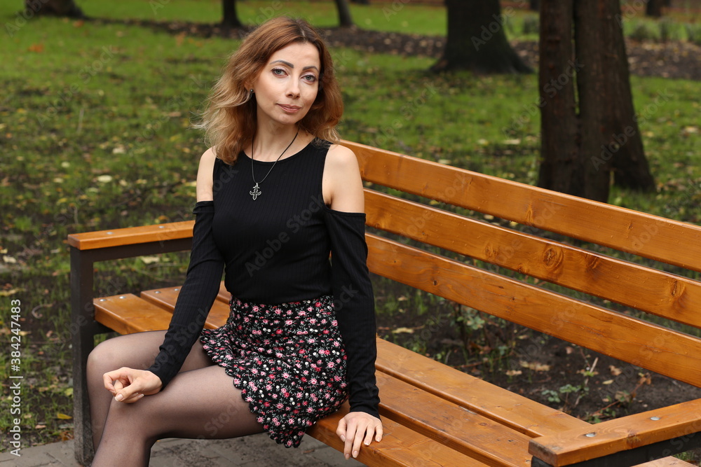 Woman sitting on the bench in the park Woman sitting on the bench in the park