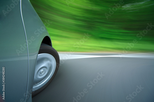 新緑の中を走るハイブリッドカーのタイヤ © Paylessimages