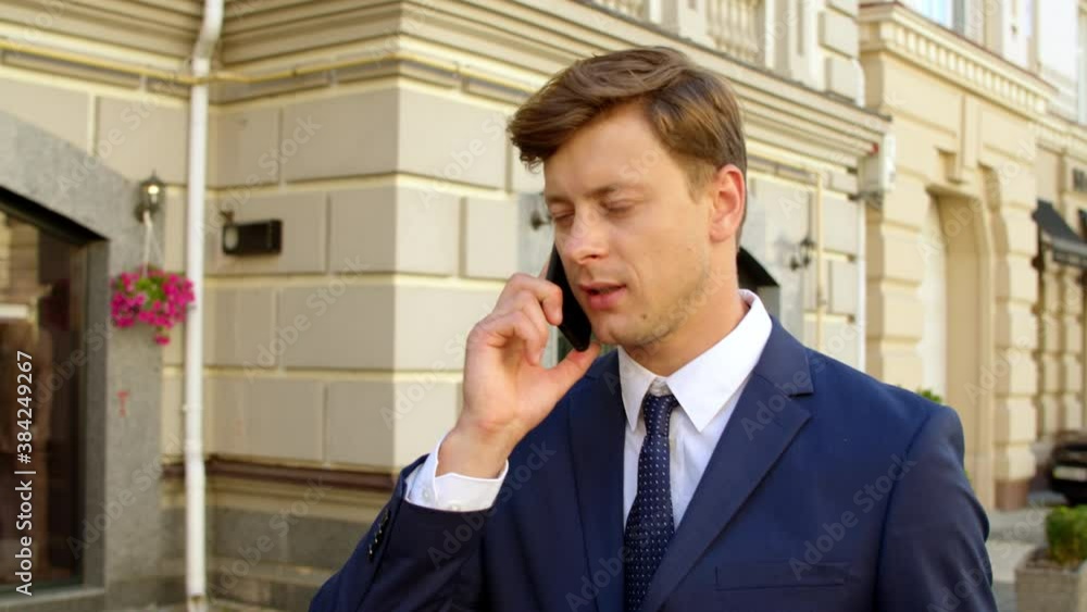 Portrait man talking mobile phone outside. Guy walking with smartphone outdoors Portrait man talking mobile phone outside. Guy walking with smartphone outdoors