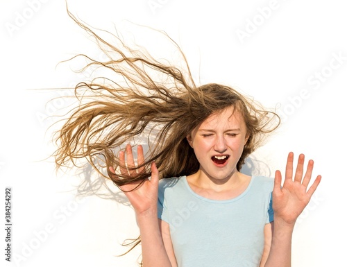 Girl expresses surprise when hair is blown straight out in a big wind