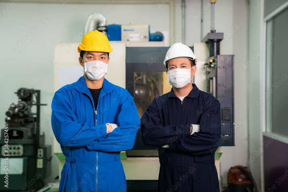 Asian engineer man and worker wearing mask and uniform safety workers arm crossed and perform maintenance in factory working CNC machine lathe metal, industry work man concept.. Asian engineer man and worker wearing mask and uniform safety workers arm crossed and perform maintenance in factory working CNC machine lathe metal, industry work man concept..