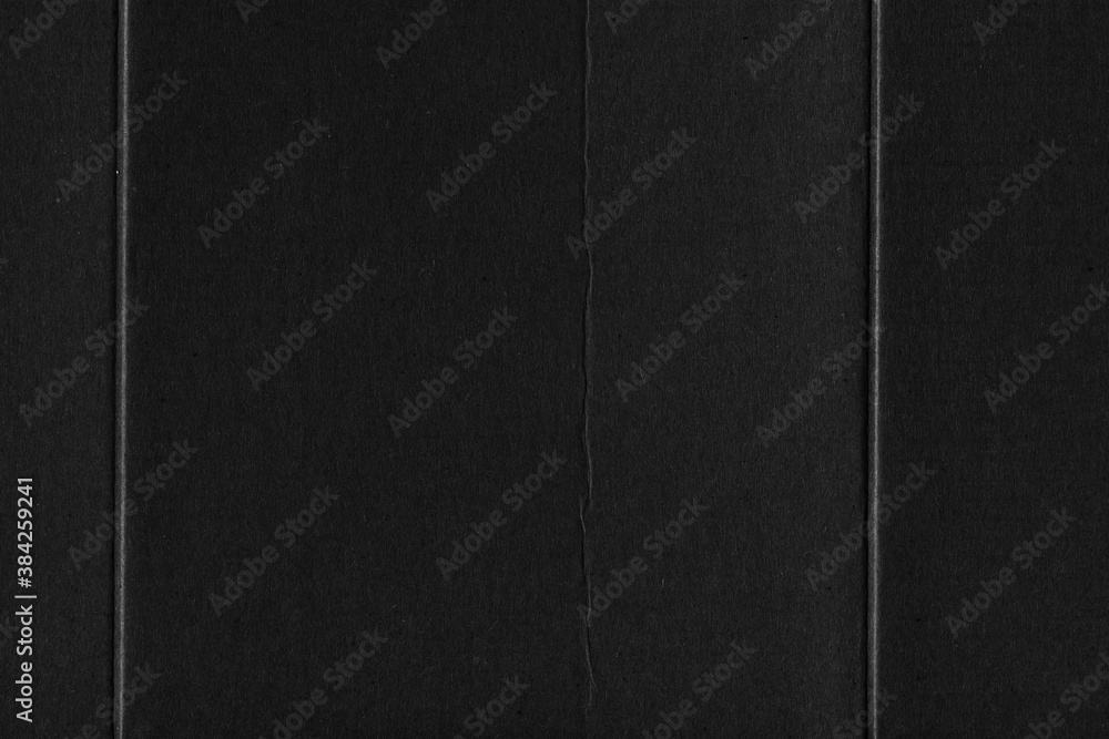 Fototapeta premium A black vintage rough sheet of carton. Recycled environmentally friendly cardboard paper texture. Simple gray minimalist papercraft background.