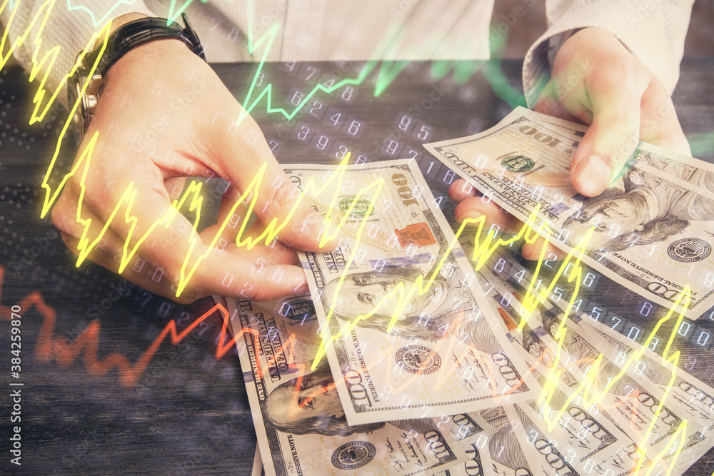 Multi exposure of financial graph drawing hologram and USA dollars bills and man hands. Analysis concept. Multi exposure of financial graph drawing hologram and USA dollars bills and man hands. Analysis concept.
