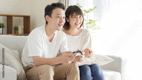 リビングでテレビゲームをするカップル・夫婦