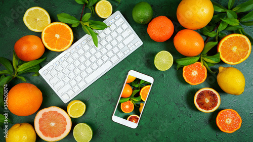 Fototapeta Naklejka Na Ścianę i Meble -  Health food theme background workspace with citrus fruit on dark green textured background. Top view blog hero header creative composition flat lay with negative copy space.