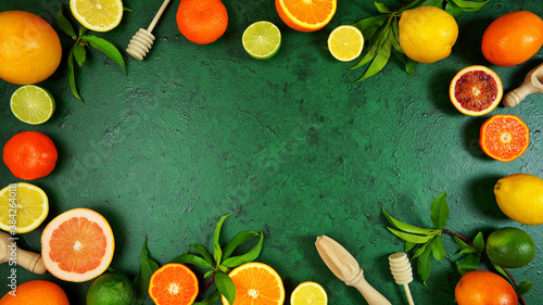 Health food theme background workspace with citrus fruit on dark green textured background. Top view blog hero header creative composition flat lay with negative copy space.