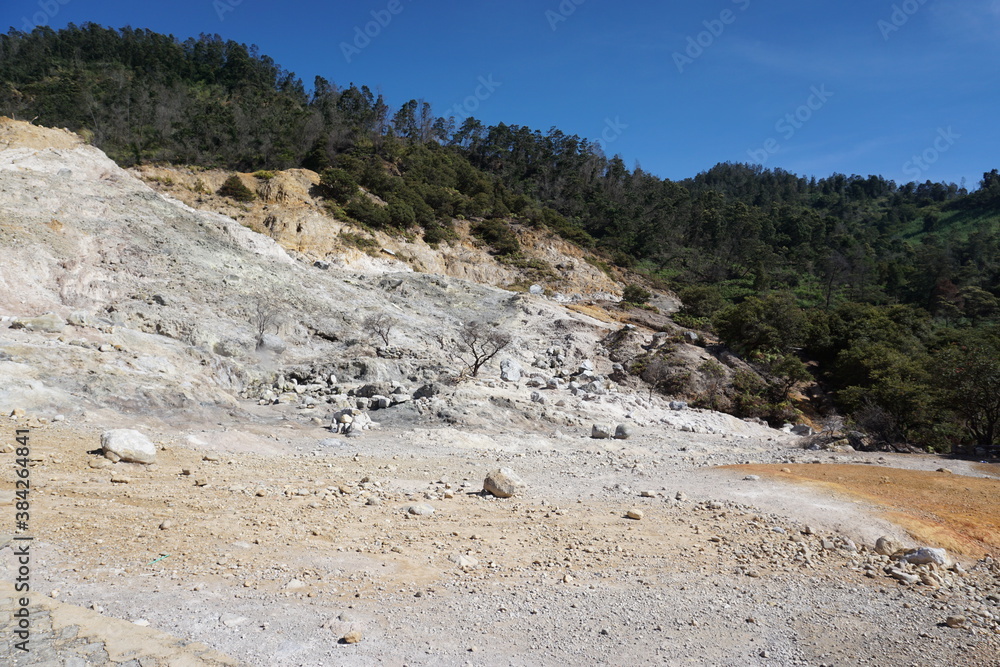 Sikidang crater tourist spot with a background of limestone mountain slopes under the blue sky. Wallpaper