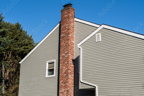 Photography Side of older style white house with tall red brick chimney blue