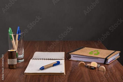 Una vista de alto ángulo de bolígrafos ecológicos, blocs de notas y una unidad flash USB sobre la mesa - concepto medioambiental photo