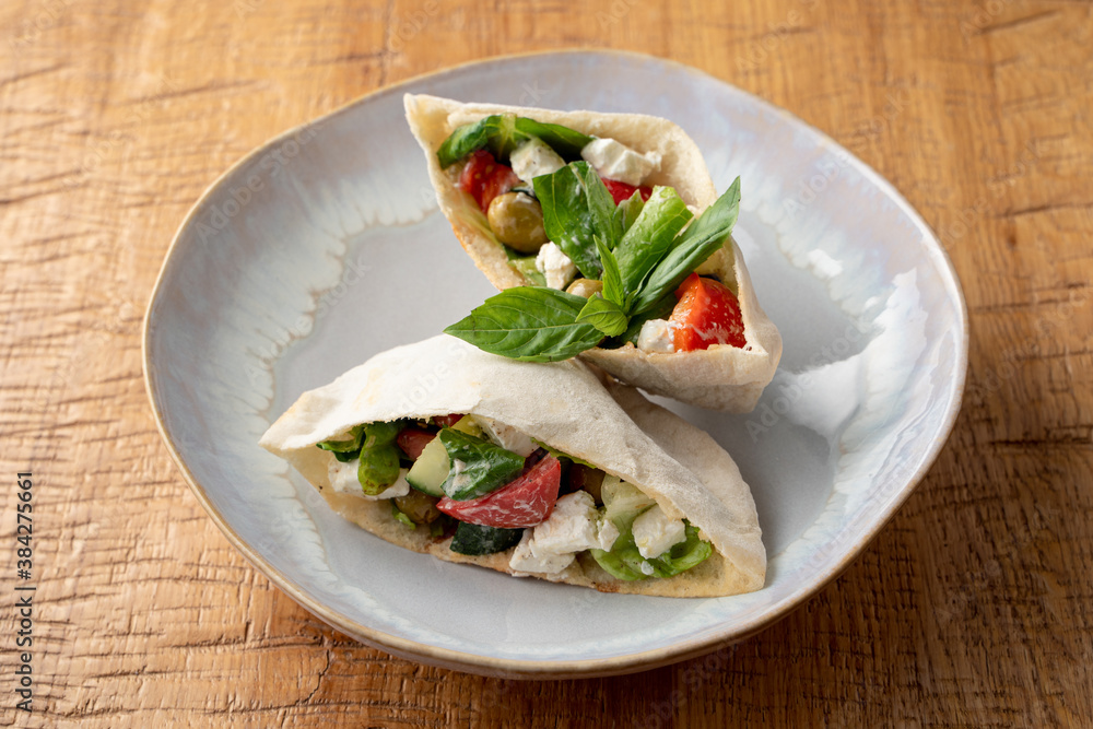 Greek pita with salad, feta and olives on a white plate, close up, high angle Greek pita with salad, feta and olives on a white plate, close up, high angle