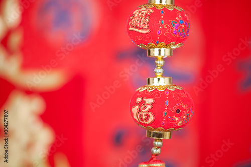 A string of lantern ornaments hung before the red spring couplets.The Chinese character on the lantern means "good luck"