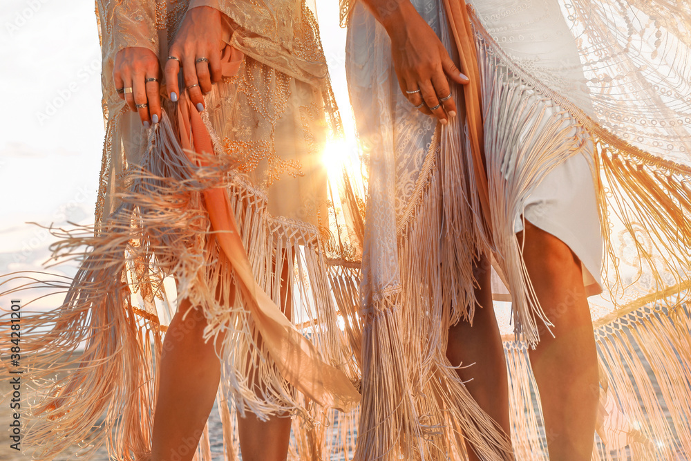 two beautiful young woman in elegant boho dresses oudoors at sunset - obrazy, fototapety, plakaty 