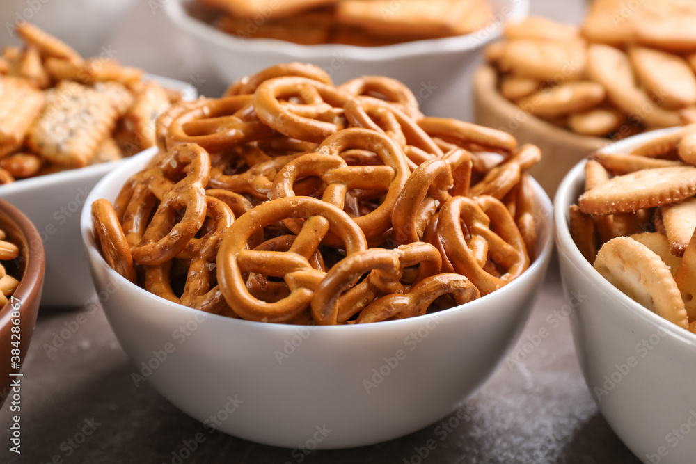 Delicious crackers in bowls on table, closeup Delicious crackers in bowls on table, closeup