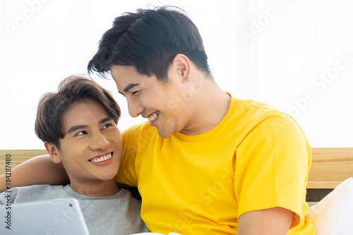 Asian gay homosexual couple hug and embracing on the bed.  Gender equality and right concept, playful and romantic moment.