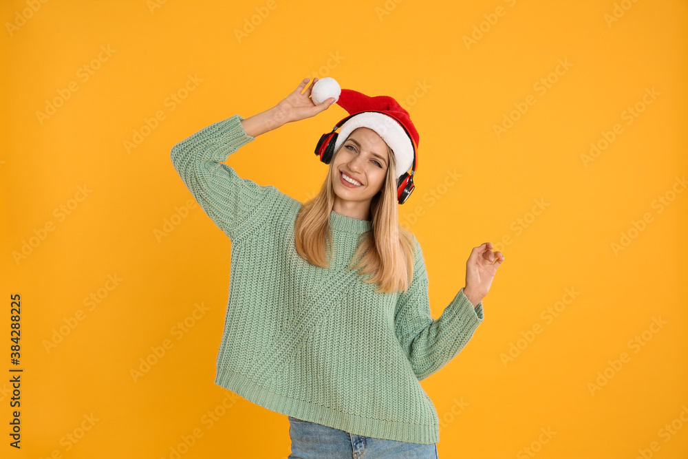 Happy woman with headphones on yellow background. Christmas music Happy woman with headphones on yellow background. Christmas music