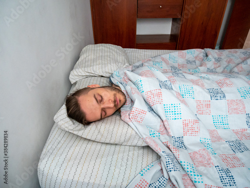 Young Caucasian Male Sleeping in his Bed in the Morning