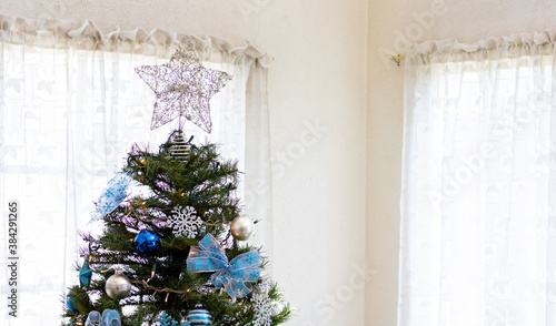 A white star on the top of a christmas tree