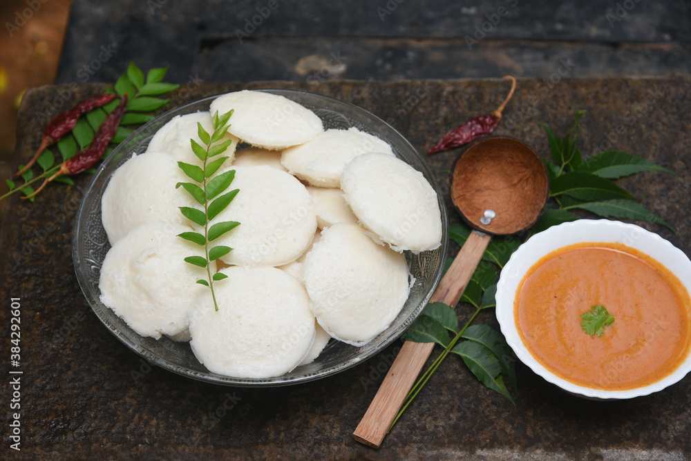 Indian idly served on traditional vegetarian food. Lots of many fresh steamed Indian Idly , Idli rice cake. South Indian breakfast idly sambar or Sambhar red coconut chutney Indian idly served on traditional vegetarian food. Lots of many fresh steamed Indian Idly , Idli rice cake. South Indian breakfast idly sambar or Sambhar red coconut chutney