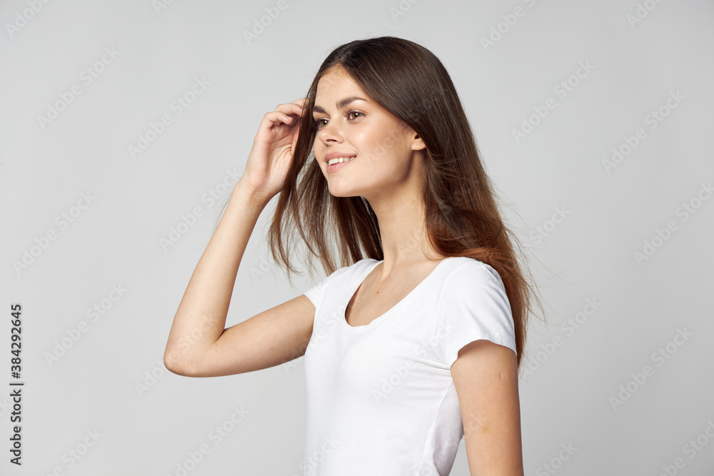 Happy woman removes hair from her face and smiles side view Happy woman removes hair from her face and smiles side view