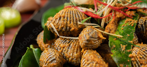 Cockles sauteed in curry powder with bell peppers and tomatoes.