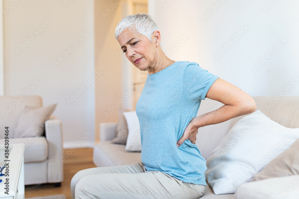 Upset mature middle aged woman feels back pain massaging aching muscles, sad senior older lady suffers from low-back lumbar pain sitting in incorrect sedentary posture, backache radiculitis concept Upset mature middle aged woman feels back pain massaging aching muscles, sad senior older lady suffers from low-back lumbar pain sitting in incorrect sedentary posture, backache radiculitis concept