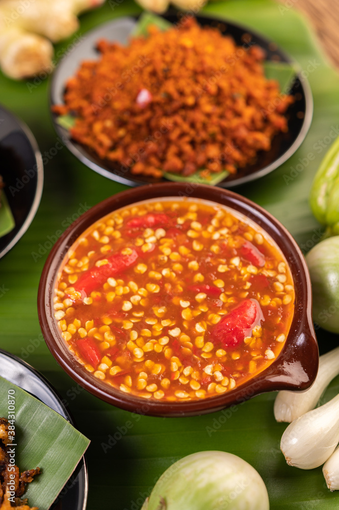 Chili sauce and ingredients placed on banana leaves.