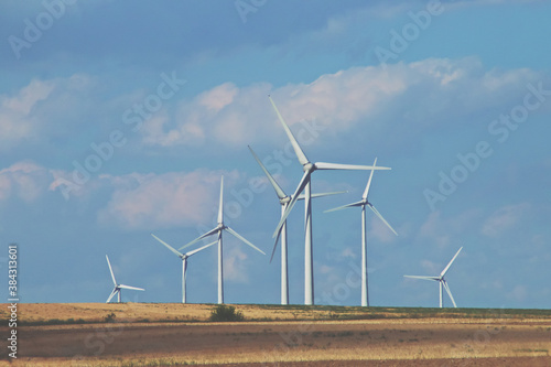 Campos de cereales y turbinas de viento eléctricas en un bonito cielo azul con nubes al atardecer. Campo de cereales en el sur de Rumania, Haidar cerca de Tulcea.