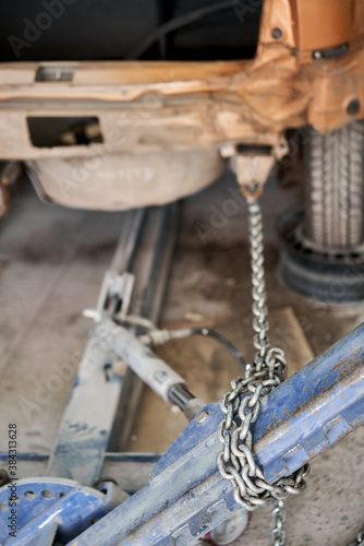 A broken car with a violation of geometry is on the stocks for leveling. Restoration of vehicles with chain and hook. Repair in the workshop and auto
