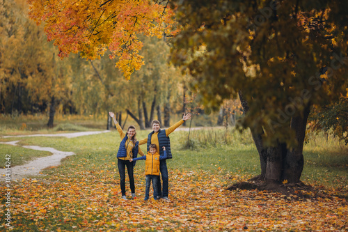 A happy family standing next to a tree in fall
