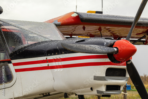 old small civil aircraft parked at the airport in the rain in autumn