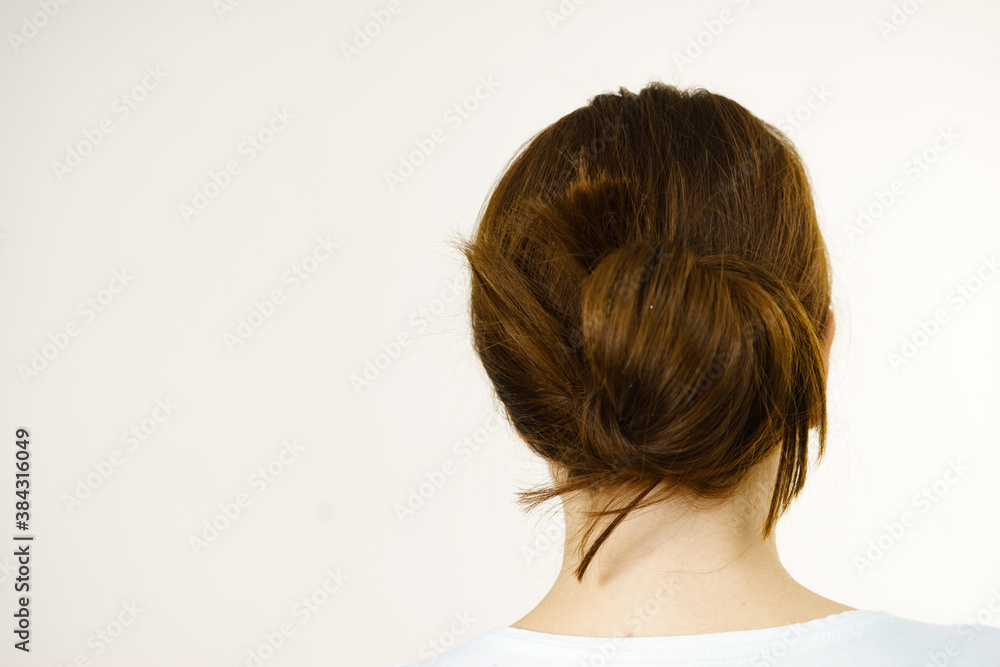 Girl with brown long hair tied in bun