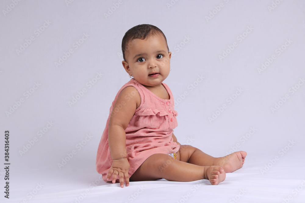 cute Indian cheerful baby sitting and smiling over white. cute Indian cheerful baby sitting and smiling over white.