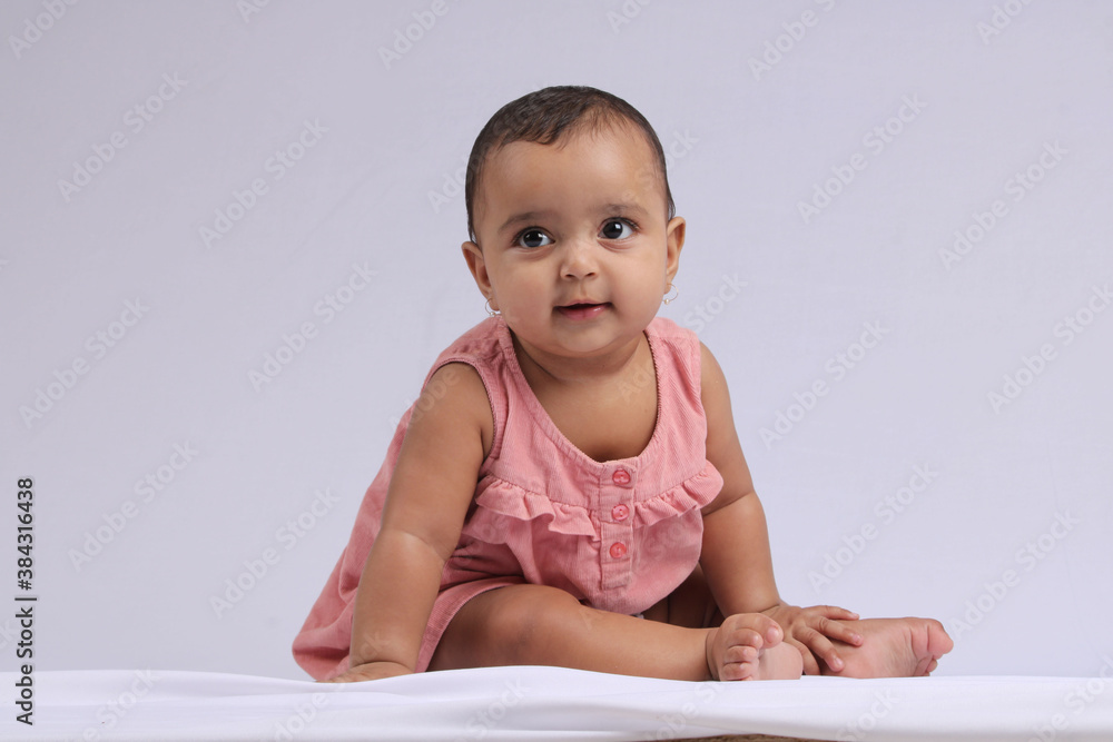 cute Indian cheerful baby sitting and smiling over white. cute Indian cheerful baby sitting and smiling over white.