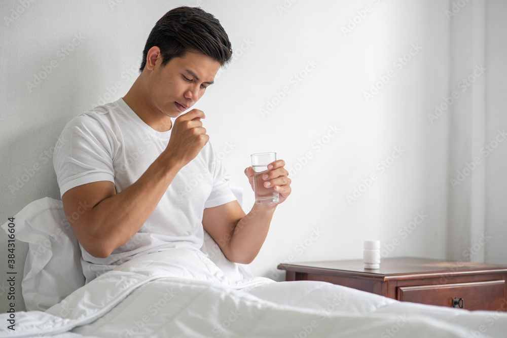 A man who is unwell on the couch and is about to take antibiotics. A man who is unwell on the couch and is about to take antibiotics.