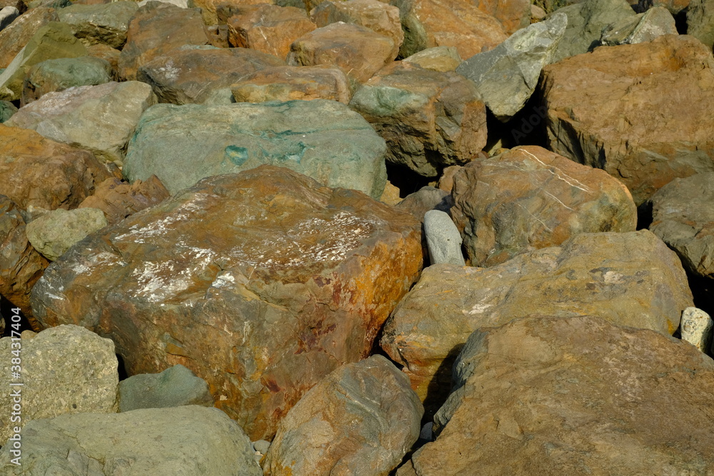 Background from a stone of igneous rock. Wallpaper made of textures of boulders of volcanic origin. Surface of granite, diabase, gabbro interspersed with spar, quartz. Sea shore. Day. Georgia. Background from a stone of igneous rock. Wallpaper made of textures of boulders of volcanic origin. Surface of granite, diabase, gabbro interspersed with spar, quartz. Sea shore. Day. Georgia.