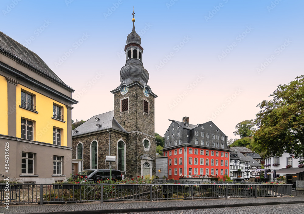 Church and colorful buildings in city center of Monschau, Germany.