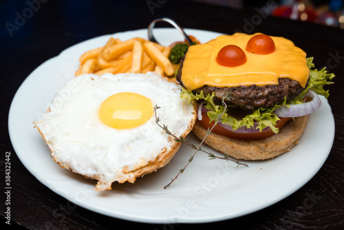 Cheeseburger with egg and french fries 